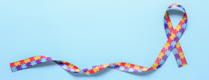 Multi-coloured ribbon with puzzle piece pattern on a blue background