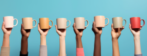 A row of hands hold up coffee cups against a blue background